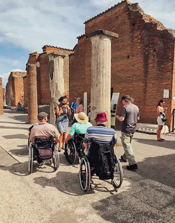 Turistas en silla de ruedas en el parque arqueológico de Pompeya